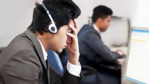 Call centre worker with head in his hand