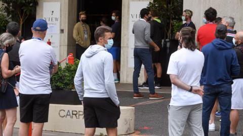 Players queue for a coronavirus test at a hotel in Melbourne