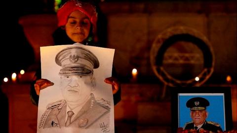 A girl holds a poster of India"s Chief of Defence Staff General Bipin Rawat during a candle light vigil to pay homage to the general and others who died in a helicopter crash, inside Indian army headquarters, in Srinagar December 10, 2021