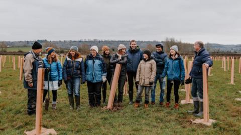 A team in a field with tree planters