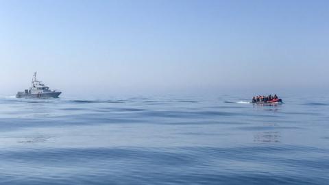 A Border Force boat approaches migrants in the English Channel