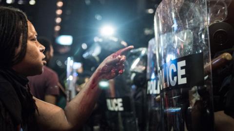 Protester faces riot police