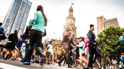 People walk across a street in Australia