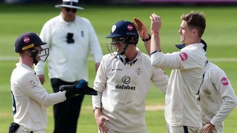 Alex Thomson (right) celebrates taking a wicket