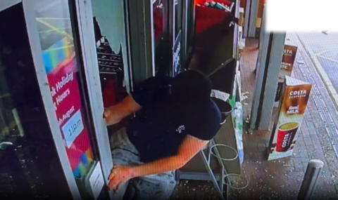 Jeremiah Connors climbing out of a shop door.