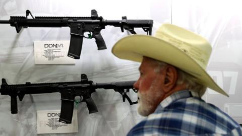 Man looks at gun at NRA convention in Texas