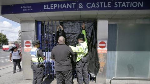 Police officers close the gates at Elephant & Castle station
