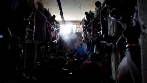 Prisoners cram shoulder to shoulder to watch TV in their crowded cell inside the National Penitentiary in downtown Port-au-Prince