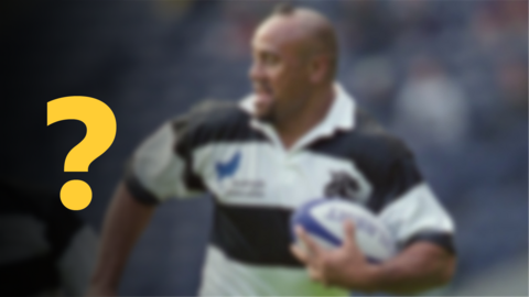 A blurred image of a rugby player