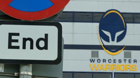The Worcester Warriors badge behind an End sign