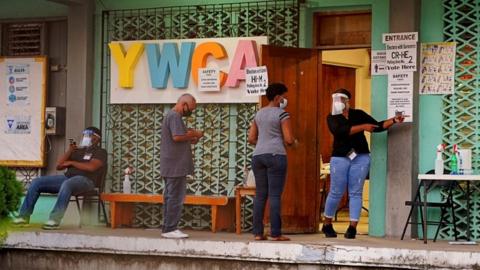 People queue to enter a polling station to cast their votes during the election for a new prime minister, in Belize City, Belize November 11, 2020.