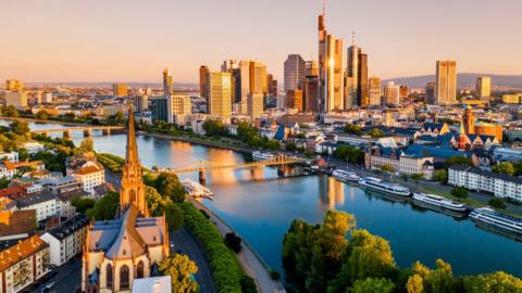 Frankfurt skyline bathed in a golden glow of sunlight.