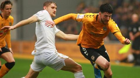 Finn Azaz of Newport County takes on Nathan Smith of Port Vale