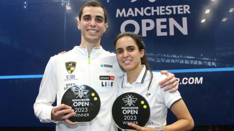 Ali Farag and Nour El Tayeb hold up their trophies at the Manchester Open