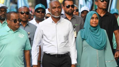 Maldives' President Mohamed Muizzu (C) along with his supporters take part in an election campaign rally on the eve of the country's parliamentary election