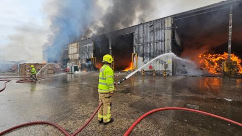Firefighters tackling flames at the warehouse