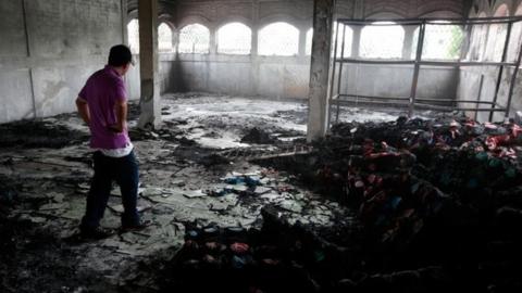 A man stands inside a burned house where, according to local media, six people died, during a protest against Nicaragua's President Daniel Ortega's in Managua, Nicaragua June 16, 2018.