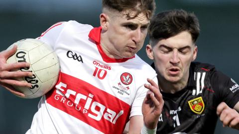 Derry's Peter McCullagh in challenged by Oran Cunningham of Down