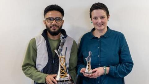 Student Ritik Tailor (left) holds the 2024 Randox Grand National trophy with silversmith Cara Murphy