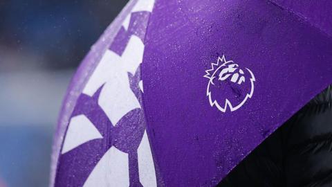 The logo / badge of the Premier League is seen on an umbrella