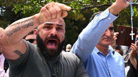 Pro Catholic supporters yell during a protest by an LGBTI group outside the pontifical requiem Mass for Cardinal George Pell.