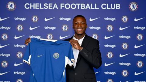 Moises Caicedo holding up his new Chelsea shirt