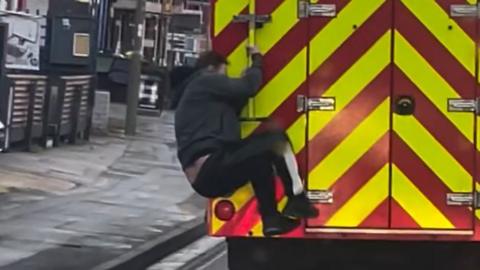 Man jumps on back of fire engine