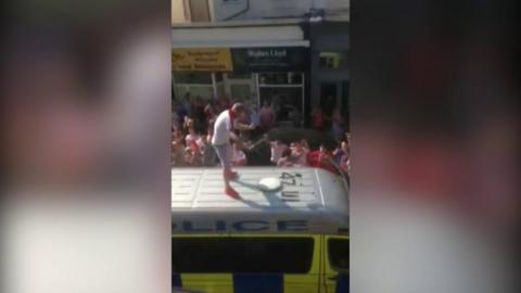 Man on top of police van