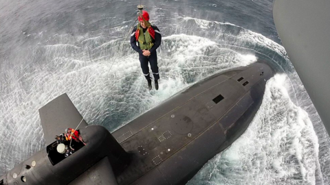 President Macron is lowered down from helicopter aboard the nuclear submarine