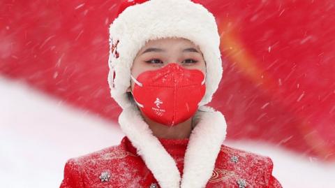 A Chinese hostess stands in the snow