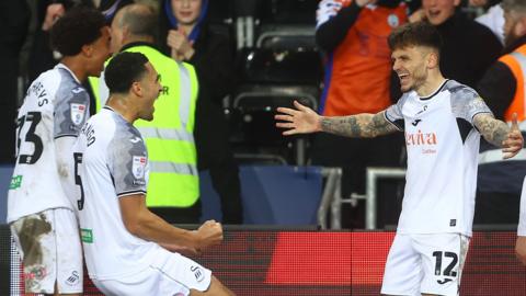 Jamie Paterson celebrates with Ben Cabango and Bashir Humphreys