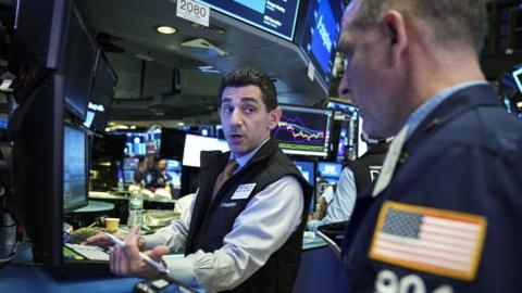 Traders and financial professionals work at the opening bell on the floor of the New York Stock Exchange (NYSE), October 12, 2018 in New York City.