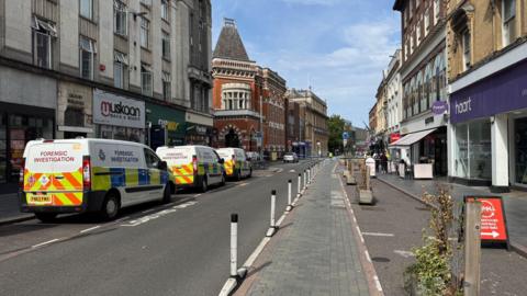 Forensic investigation police vehicles in Granby Street alongside a police cordon