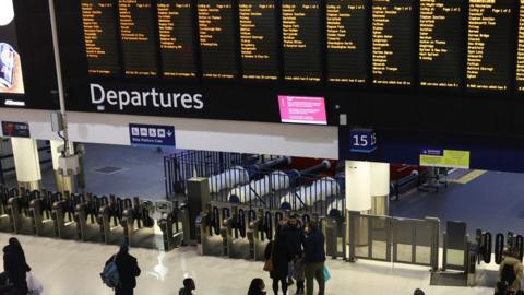 Rail users stood looking at departure boards