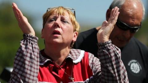 woman raising hands to sky