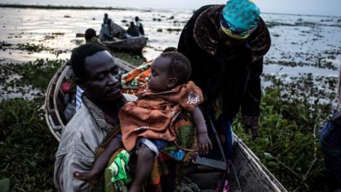 Internally displaced Congolese return to the shore line of lake Albert after spending the night out in the lake for safety on March 05, 2018 in Tchomia.