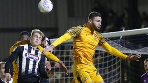 Ryan Inniss of Newport County rises to meet a corner