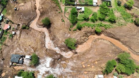 Aerial image showing flooded river and houses in Kamuchiri on 29 April