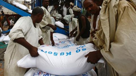 Sudanese workers offload US aid destined for South Sudan from the World Food Programme (WFP)