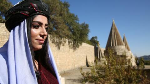A woman arrives for the inauguration ceremony of the new Yazidi spiritual leader in northern Iraq
