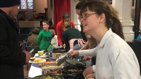 A volunteer hands out plates