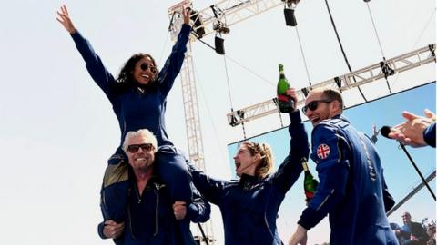 Sir Richard Branson celebrates with the crew of Virgin Galactic with Sirisha Bandla perched on his shoulder