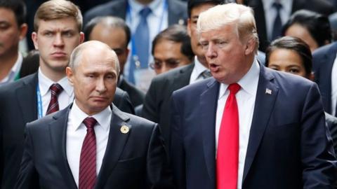 In this file photo taken on November 11, 2017 US President Donald Trump (R) and Russian President Vladimir Putin talk as they make their way to take the "family photo" during the Asia-Pacific Economic Cooperation (APEC) leaders" summit in the central Vietnamese city of Danang.