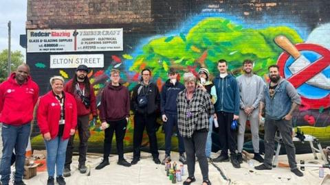 The team involved in creating the mural with Theresa Cave in centre