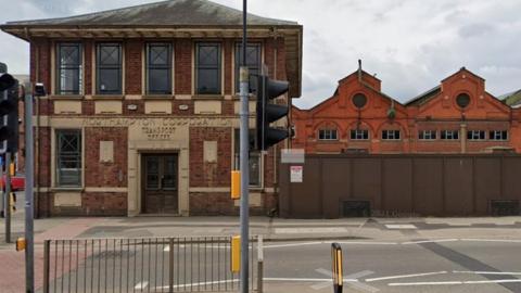 1900s two-storey building next to bus depot sheds