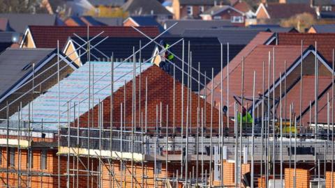 view of rooftops being constructed on a housing estate