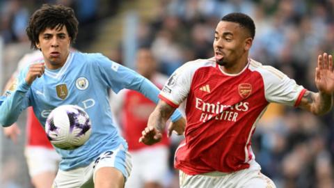 Manchester City's Rico Lewis battles Arsenal's Gabriel Jesus for the ball