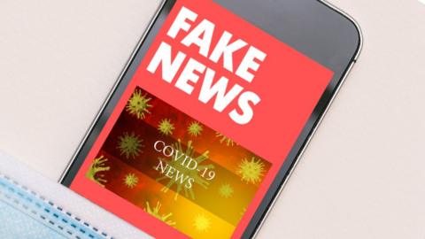 Mocked up image showing mobile phone with fake news text