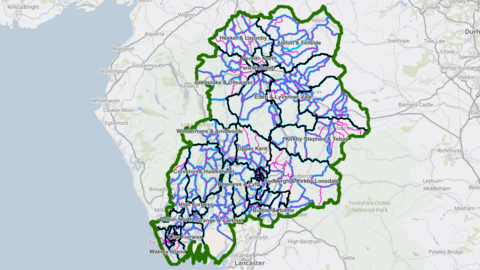 A map of with a green line circling the Westmorland and Furness Council area. Dark blue lines indicate the districts within. Purple and pink lines indicate the current and proposed wards. 