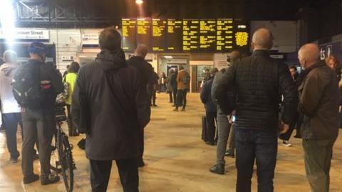 Commuters looking at boards